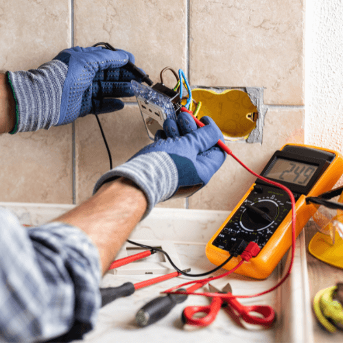 Certified electrician from 2 Sisters Electrical installing a wall socket in Johannesburg.